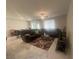 Spacious living room with a large sectional sofa, ceiling fan, and a decorative rug at 7527 Ardenno St, North Las Vegas, NV 89084