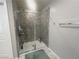 Shower with glass door and patterned tiles at 7527 Ardenno St, North Las Vegas, NV 89084