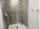 Modern bathroom featuring a glass shower enclosure with stylish, patterned walls at 7527 Ardenno St, North Las Vegas, NV 89084