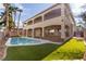 Beautiful backyard with a sparkling pool, covered patio, and lush artificial grass at 7616 Gossamer Wind St, Las Vegas, NV 89139