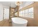 Beautiful bathroom features a glass shower, soaking tub, tiled walls and modern fixtures at 7616 Gossamer Wind St, Las Vegas, NV 89139