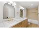 Bright bathroom boasts a double vanity, modern sinks, gold fixtures, and a soaking tub at 7616 Gossamer Wind St, Las Vegas, NV 89139