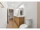 Bathroom featuring a double vanity with modern sinks, gold fixtures, and wood-look floors at 7616 Gossamer Wind St, Las Vegas, NV 89139