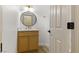 Stylish powder room featuring a wood vanity, round mirror, and modern fixtures, creating an elegant and functional space at 7616 Gossamer Wind St, Las Vegas, NV 89139