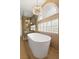 Bathroom features a glass shower, soaking tub, tile walls, and modern lighting at 7616 Gossamer Wind St, Las Vegas, NV 89139