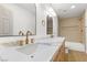 Bright bathroom featuring double sinks with white countertop and wooden vanity at 7616 Gossamer Wind St, Las Vegas, NV 89139