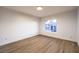 This bedroom has wood flooring, a large window, and ample space at 7616 Gossamer Wind St, Las Vegas, NV 89139