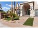 Welcoming front entrance featuring desert landscaping, a brick walkway, and an arched entryway at 7616 Gossamer Wind St, Las Vegas, NV 89139