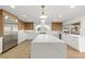 Spacious kitchen with stainless steel refrigerator, an island with white countertop, and white cabinets at 7616 Gossamer Wind St, Las Vegas, NV 89139