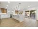 Modern kitchen with island, light wood floors, bright lighting, and access to outdoor pool area at 7616 Gossamer Wind St, Las Vegas, NV 89139
