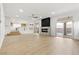 Open concept living room with modern fireplace, wood floors, and easy access to backyard at 7616 Gossamer Wind St, Las Vegas, NV 89139