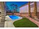 Backyard pool with artificial turf, rock accents, and concrete border at 7616 Gossamer Wind St, Las Vegas, NV 89139