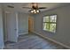 Bedroom with wood-look flooring, ceiling fan, and window view at 7733 Donner Peak St, Las Vegas, NV 89166