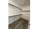 Walk-in closet with built-in shelving and wood-look flooring at 7733 Donner Peak St, Las Vegas, NV 89166