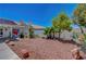 Large backyard with stone landscaping, a white brick wall, and an outdoor grill is perfect for entertaining guests at 7874 Trail Boss Ct, Las Vegas, NV 89113
