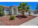 A single story home featuring desert landscaping, a palm tree, and a two car garage at 7874 Trail Boss Ct, Las Vegas, NV 89113