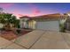 Charming single-Gathering home exterior with a two-car garage, concrete driveway, and festive holiday lights at 7874 Trail Boss Ct, Las Vegas, NV 89113