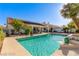 Beautiful pool view with a covered patio, rock features, palm trees and a sun deck offer an exceptional outdoor experience at 7874 Trail Boss Ct, Las Vegas, NV 89113