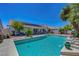 Backyard pool features a covered patio, rock features, and ample space for entertaining and enjoying the sunshine at 7874 Trail Boss Ct, Las Vegas, NV 89113