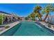 Gorgeous pool view featuring a covered patio, palm trees, and outdoor seating provides an ideal space for relaxation at 7874 Trail Boss Ct, Las Vegas, NV 89113