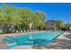 Community pool surrounded by lounge chairs, trees, and a glimpse of nearby homes at 8324 W Charleston Blvd # 1036, Las Vegas, NV 89117