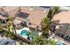 Private backyard oasis featuring a sparkling swimming pool, covered patio, and lush palm trees at 8326 Mount Nido Dr, Las Vegas, NV 89147