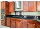 A spacious kitchen with stainless steel appliances and custom wood cabinetry and black countertops at 8326 Mount Nido Dr, Las Vegas, NV 89147