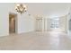 Spacious living room with tile flooring, chandelier, and large window letting in natural light at 8326 Mount Nido Dr, Las Vegas, NV 89147