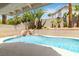 Beautiful pool with a serene waterfall feature and mature tropical landscaping at 8326 Mount Nido Dr, Las Vegas, NV 89147