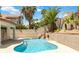 Sparkling blue pool with a rock waterfall feature surrounded by lush landscaping at 8326 Mount Nido Dr, Las Vegas, NV 89147