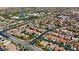 Neighborhood aerial showing numerous single-Gathering homes with red-tile roofs in a desert-like environment with some green landscaping at 10089 Clifton Forge Ave, Las Vegas, NV 89148
