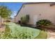 Backyard featuring a putting green, mature trees, and easy access to the home through a side door at 10089 Clifton Forge Ave, Las Vegas, NV 89148