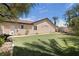 Spacious backyard with artificial turf, mature palm trees, and a charming stucco fence for added privacy at 10089 Clifton Forge Ave, Las Vegas, NV 89148