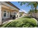 Backyard patio with outdoor kitchen, cozy seating, and manicured artificial turf, great for entertaining at 10089 Clifton Forge Ave, Las Vegas, NV 89148