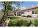 Expansive backyard featuring a covered patio, outdoor seating, artificial turf, and manicured landscaping at 10089 Clifton Forge Ave, Las Vegas, NV 89148