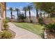 Lush backyard featuring artificial turf, a winding stone path, and mature trees, creating a serene outdoor space at 10089 Clifton Forge Ave, Las Vegas, NV 89148