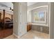 The view into a bathroom featuring an alcove tub with granite surround and a peek into the bedroom at 10089 Clifton Forge Ave, Las Vegas, NV 89148
