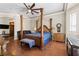 A primary bedroom featuring wood floors, a four-poster bed, seating and plenty of space at 10089 Clifton Forge Ave, Las Vegas, NV 89148