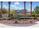 Elegant community entrance with stone signage, lush landscaping, and mature palm trees, welcoming residents and guests at 10089 Clifton Forge Ave, Las Vegas, NV 89148