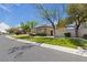 Street view of a well-maintained home with desert landscaping, mature trees, and lush green lawns at 10089 Clifton Forge Ave, Las Vegas, NV 89148