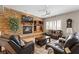 Comfortable living room with stone fireplace, built-in shelving and leather furniture at 10089 Clifton Forge Ave, Las Vegas, NV 89148