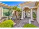 Inviting front entrance with double doors, stone pathway, columns, and mature landscaping at 10314 Premia Pl, Las Vegas, NV 89135