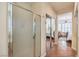 Hallway leading to the main bedroom features tile floors, mirrored closet doors, and shower with glass door at 10314 Premia Pl, Las Vegas, NV 89135