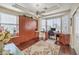 Office space featuring custom built-ins, hardwood floors, a ceiling fan, and large windows for natural light at 10314 Premia Pl, Las Vegas, NV 89135