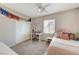 Comfortable bedroom with a ceiling fan, carpet floors, desk, and natural light from the window at 10410 Nostalgia Cir, Las Vegas, NV 89135