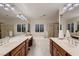 Bright bathroom featuring dual vanities, a soaking tub, and a glass-enclosed shower at 11345 Espadrille Ct, Las Vegas, NV 89138