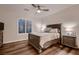 Comfortable bedroom with a ceiling fan, wood-look flooring, and a window with plantation shutters at 11345 Espadrille Ct, Las Vegas, NV 89138