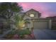 Charming two-story home featuring a well-manicured front yard with lush greenery and a spacious two-car garage at 11345 Espadrille Ct, Las Vegas, NV 89138
