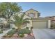 Charming two-story home featuring a well-manicured front yard with lush greenery and a spacious two-car garage at 11345 Espadrille Ct, Las Vegas, NV 89138