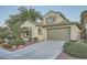 Charming two-story home featuring a well-manicured front yard with lush greenery and a spacious two-car garage at 11345 Espadrille Ct, Las Vegas, NV 89138